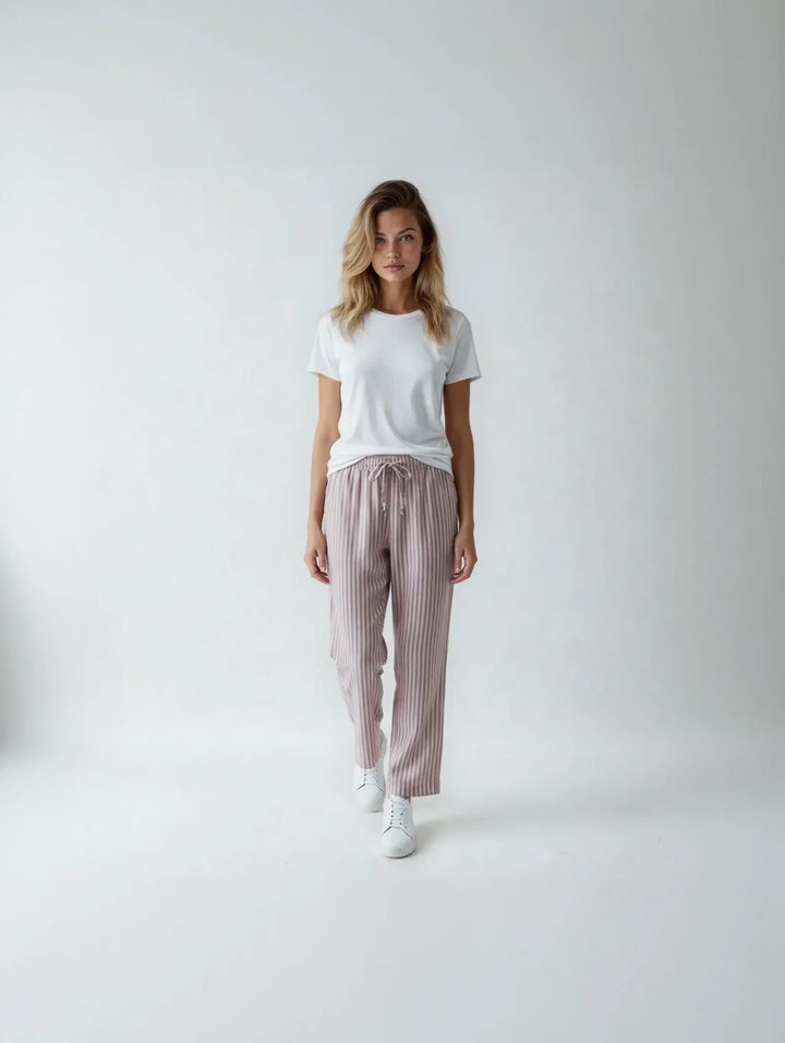 Woman wearing a white t-shirt and pink striped pants on a white background